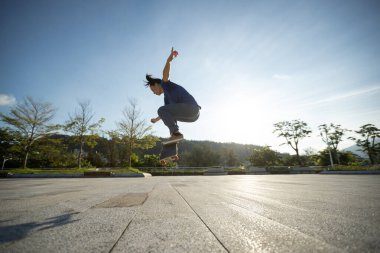 Kaykaycı şehir dışında kaykay yapıyor.