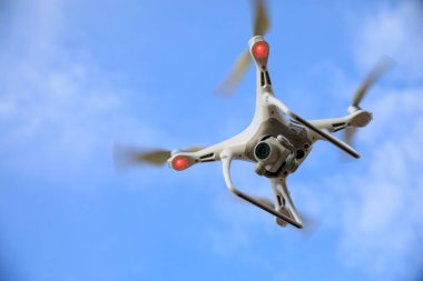 Yazın dağın tepesinde uçan kameralı beyaz dron