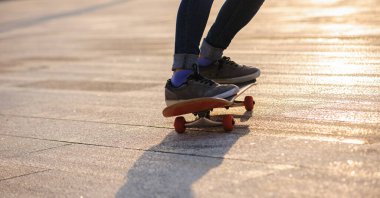 Kaykaycı şehir dışında kaykay yapıyor.