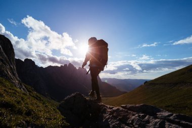 Tek başına dağ zirvesinde gezen sırt çantalı bir kadın.