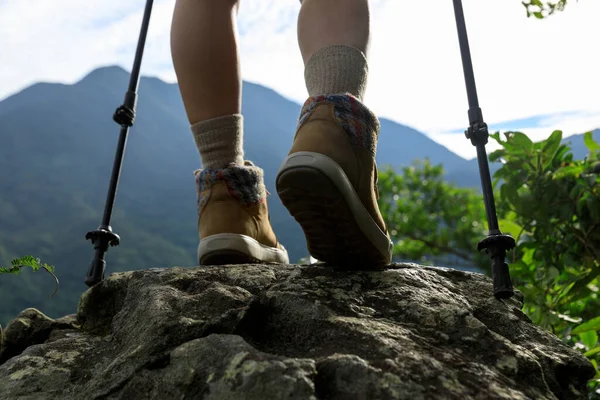 成功的女徒步旅行者的腿站在山顶的岩石上 — 图库照片