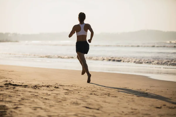 ビーチを走るフィットネス女性 — Stock fotografie