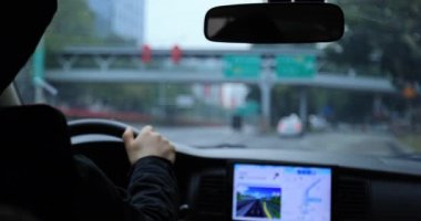 Kadın şehir yolunda araba sürüyor.