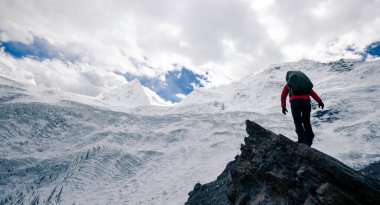 Başarılı kadın yürüyüşçü kış dağlarında yürüyüş yapıyor.