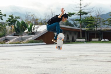 Modern şehirde Asyalı kaykaycı kadın.