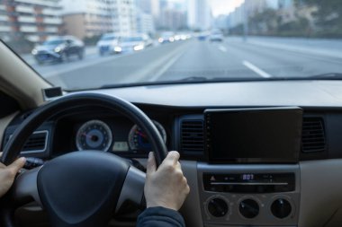 Şehir yolunda araba kullanan insanlar