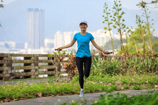 Asian woman skipping rope in park