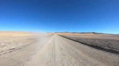 Araba çölde yolda ilerliyor.