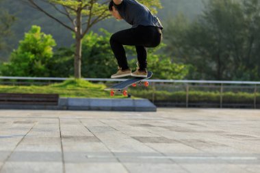 Kaykaycı şehir dışında kaykay yapıyor.