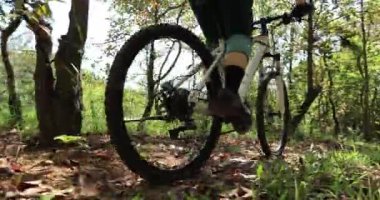 Ormanda bisiklet süren genç bir kadın.