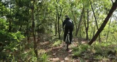 Ormanda bisiklet süren genç bir kadın.