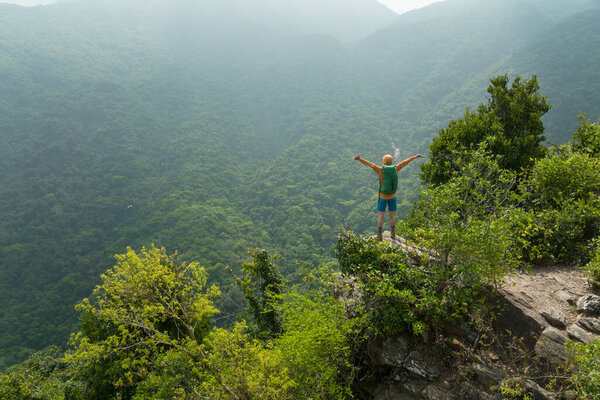 Вид с воздуха на успешного туриста с высоты горной скалы