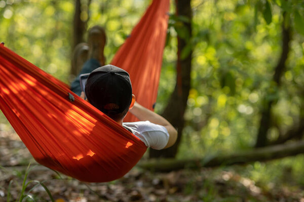 Relaxing in hammock in tropical forest