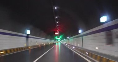 Yeraltı tünelinde ışıklarla giden araba.