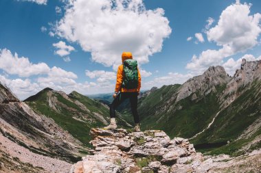 Başarılı bir kadın sırt çantalı. Gün batımı dağlarının zirvesinde yürüyüş yapıyor.
