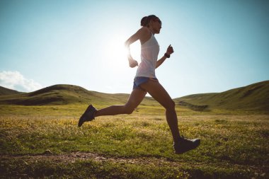 Yüksek rakımlı çayırlarda koşan genç bir fitness koşucusu.