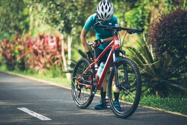 Bisikletli Kadın Yaz Parkında Bisiklet Sürerken Koltuk Yüksekliğini Ayarlıyor — Stok fotoğraf