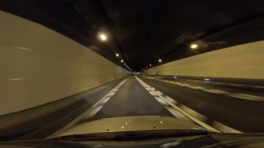 Yeraltı tünelinde ışıklarla giden araba.