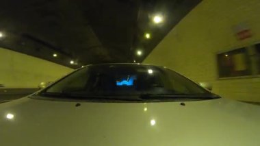 Yeraltı tünelinde ışıklarla giden araba.