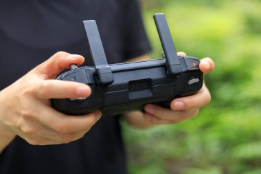 People remote control a flying drone in summer forest