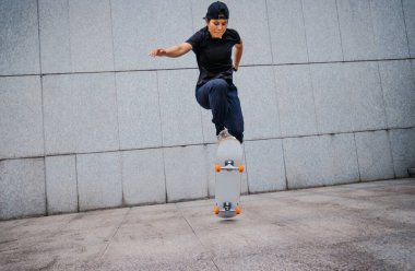 Modern şehirde Asyalı kaykaycı kadın.