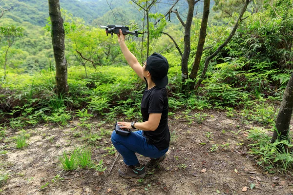 People remote control a flying drone in summer forest