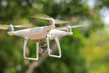 Baharda tropikal ormanda uçan kameralı beyaz dron