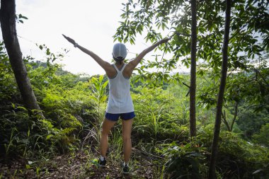 Cheering woman runner running on forest trai