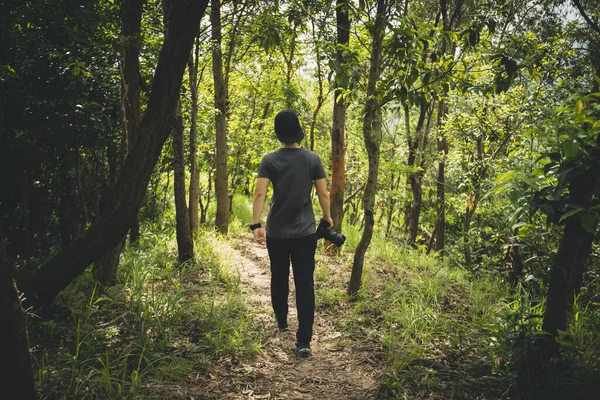 Woman photographer walking in summer forest