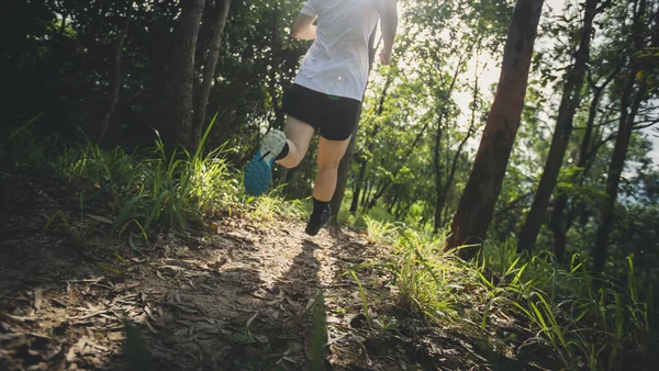 Woman runner running on forest trai