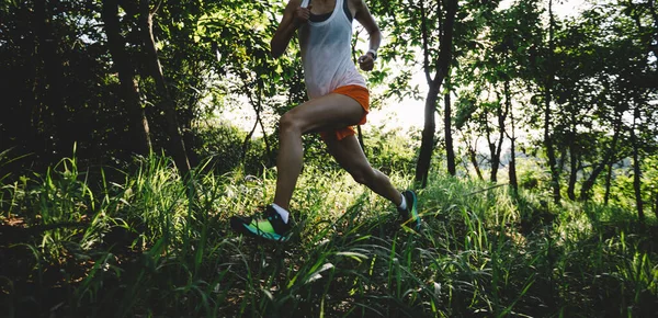 Woman runner running on forest trail