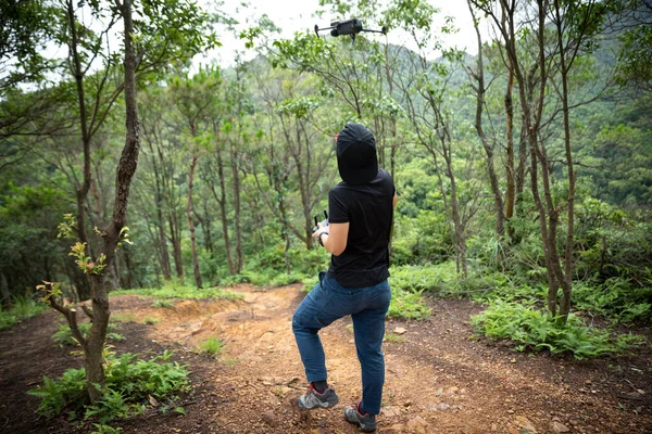 People remote control a flying drone in summer forest