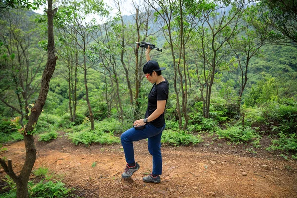 People remote control a flying drone in summer forest