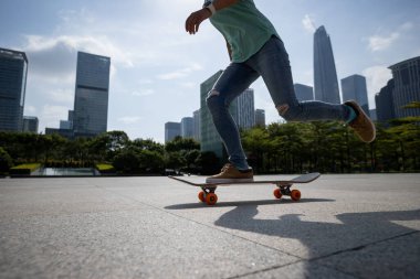 Kaykaycı şehir dışında kaykay yapıyor.