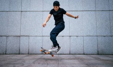 Modern şehirde Asyalı kaykaycı kadın.