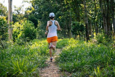 Woman trail runner running at tropical forest 