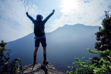 Başarılı yürüyüşçünün hava görüntüsü dağın tepesindeki tepenin manzarasının keyfini çıkar