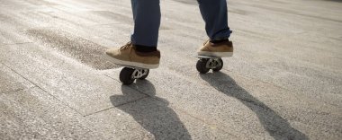 Şehirde kaykaycı ayakları kaykay yapıyor.