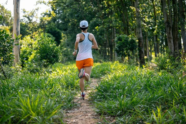 Woman trail runner running at tropical forest 