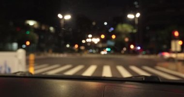 Woman driving car on city road at night