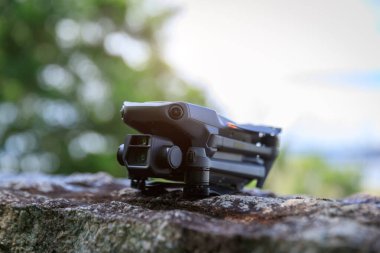 People remote control a flying drone in summer forest