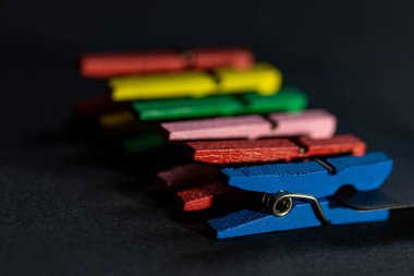 Siyah arkaplanda izole edilmiş küçük renkli elbise askısı.