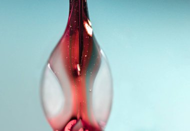 Soyut, kırmızı su damlalarının açık mavi arkaplan üzerine yakın plan görüntüleri