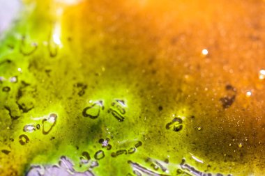 Yeşil ve kahverengi soyut, ıslak ve parlak desenli arka plan.