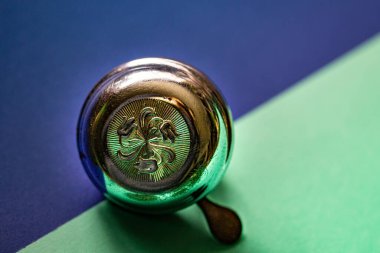 Mavi-yeşil arka planda izole edilmiş retro desenli metal bisiklet çanını kapat