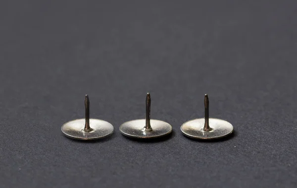 Close Três Pinos Desenho Metal Miniaturas Isoladas Uma Fileira Fundo — Fotografia de Stock