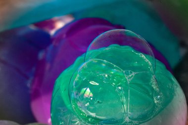 Su damlalarının yakın plan görüntüsü, renkli arkaplanda kabarcıklar