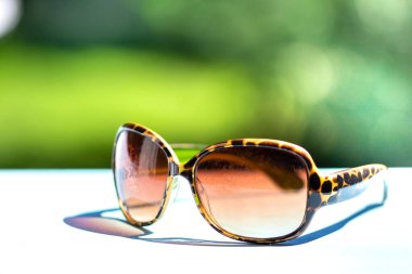 Yeşil arkaplanda desenli güneş gözlükleri