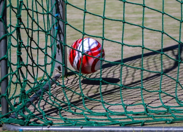 Soccer ball in the green goal net of a soccer goal