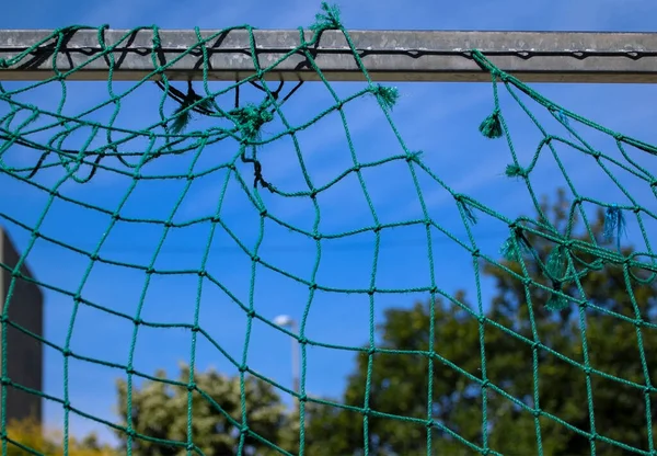 Detailní Záběr Fotbalový Gól Roztrženou Zelenou Sítí Rozmazaném Pozadí — Stock fotografie